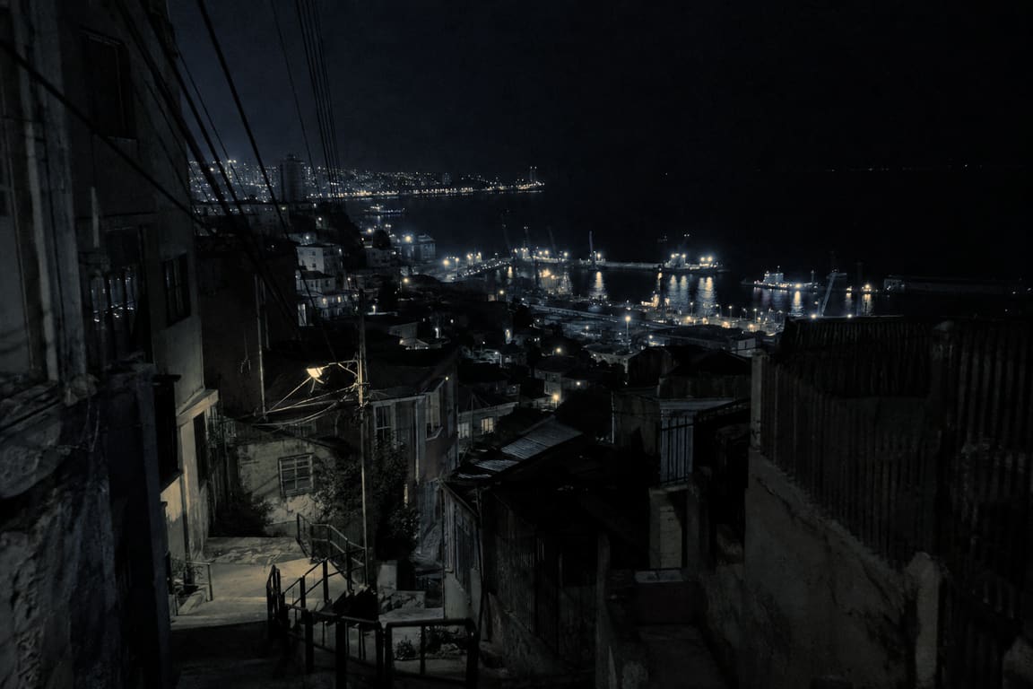 Valparaíso at 3 AM, from the top of a stairway: dark houses, a few street lamps, the port, and the black sea.
